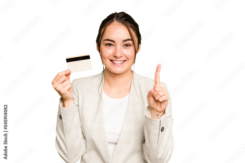 Young caucasian woman holding a credit card isolated on green chroma background showing number one with finger. Young caucasian woman holding a credit card isolated on green chroma background showing number one with finger.