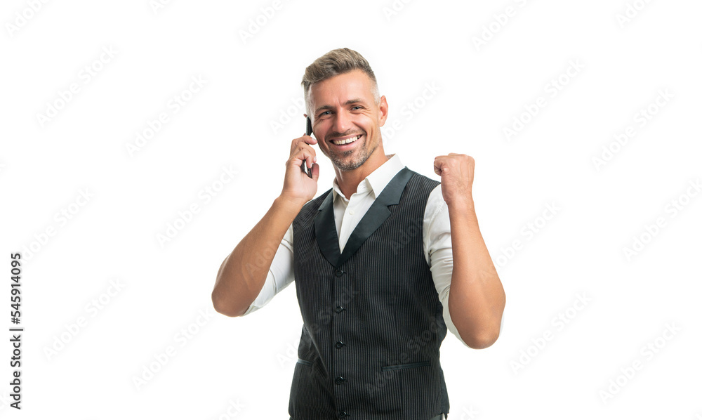 Happy businessman in suit vest talking on mobile phone making winning gesture isolated on white Happy businessman in suit vest talking on mobile phone making winning gesture isolated on white