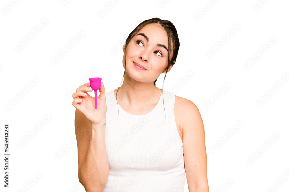 Young caucasian woman holding menstrual cup isolated on green chroma background dreaming of achieving goals and purposes Young caucasian woman holding menstrual cup isolated on green chroma background dreaming of achieving goals and purposes