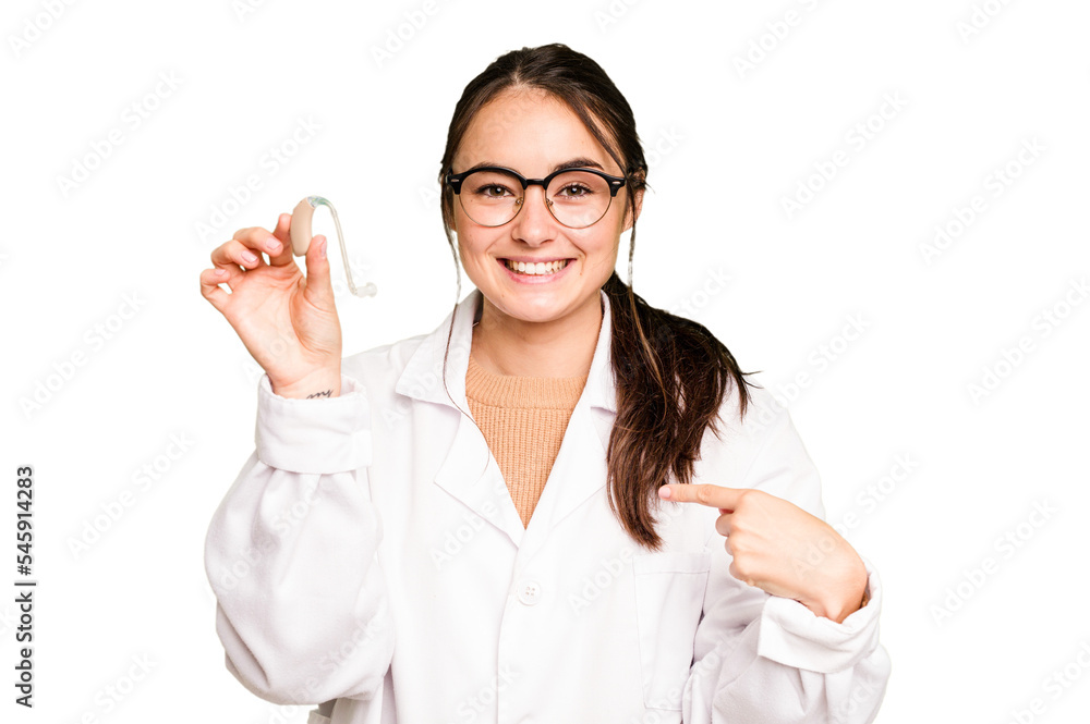 Young otorhinolaryngologist holding hearing aid isolated on green chroma background person pointing by hand to a shirt copy space, proud and confident Young otorhinolaryngologist holding hearing aid isolated on green chroma background person pointing by hand to a shirt copy space, proud and confident