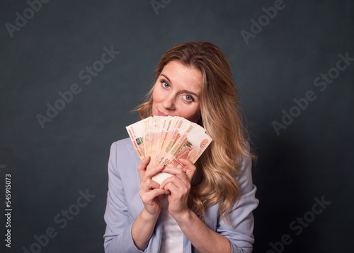 pretty young woman holding a lot of 5 thousandth bills in her hands.