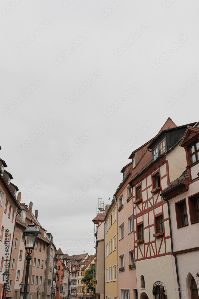Fototapeta premium Old historic architecture in Nuremberg, Germany. Traditional European old town buildings with wooden windows, shutters and colourful pastel walls. Aesthetic summer vacation, tourism background