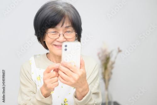 Elderly Asian adults happily learning to use a smart phone.