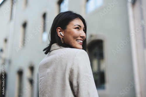 Happy woman listening to an audiobook in the city photo
