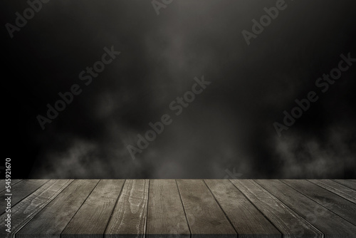 Empty wooden table for product display montages. Black background with space for your text. Smoke and mood photo.