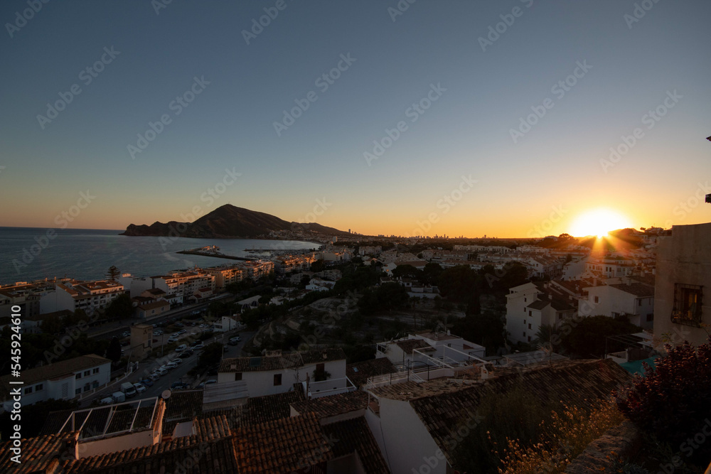Fototapeta premium Panorámica del pueblo de Altea en Alicante en la hora dorada del día, el atardecer viendo el mar y la montaña del pueblo con todas las casas del pueblo iluminadas.