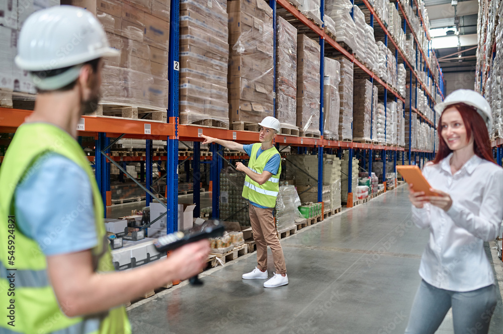 Storehouse workers working supervised by an inspector Storehouse workers working supervised by an inspector