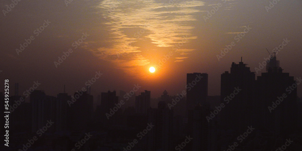 ビル群に沈んでいく夕日