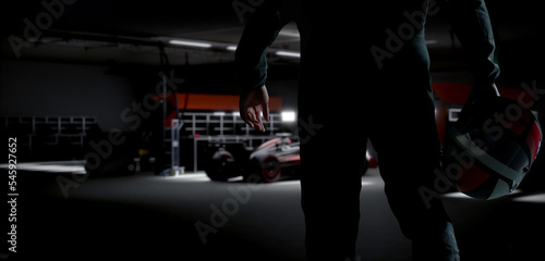 Silhouette of a racing pilot entering the pitlane garage with sports car prepared for a race