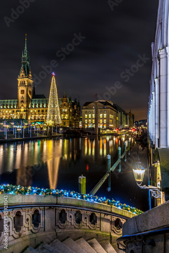Town hall of Hamburg during christmas time with illuminated christmas tree and canal