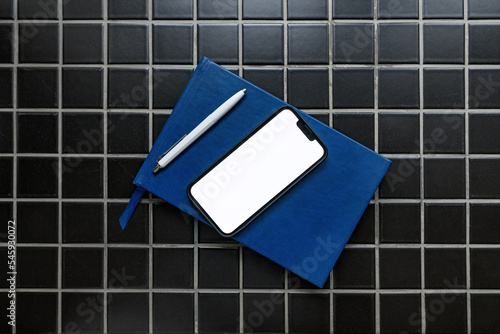 фотографія Smartphone mockup with guestbook and pencil in apartment room