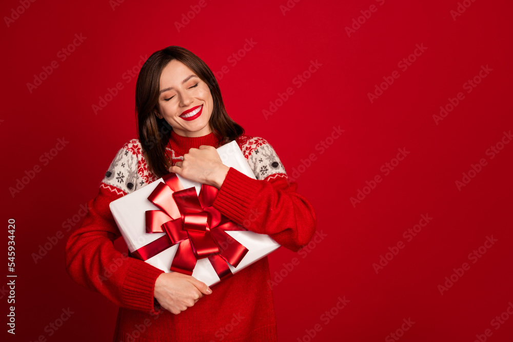 Portrait of thankful funny positive woman bob hairdo dressed red sweater hug present box eyes closed isolated on red color background Portrait of thankful funny positive woman bob hairdo dressed red sweater hug present box eyes closed isolated on red color background