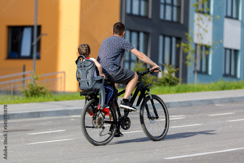 father riding bike with son in bike seat