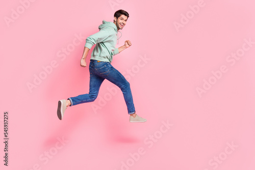 Full length profile side photo of joyful satisfied boy trendy clothes go empty space sports competitions isolated on pink color background