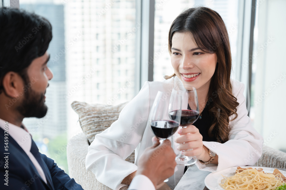 Asia businesswoman cheers with husband at restaurant and city out of window background Asia businesswoman cheers with husband at restaurant and city out of window background