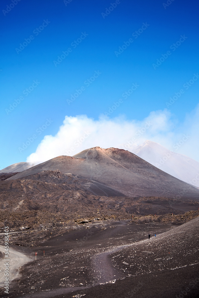 Mount Etna, Sicily, Italy. Slopes with traces of solidified lava. Crater of Mount Etna. Smoking peak of active volcano Etna.