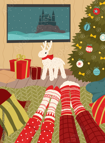 Leisure during the Christmas holidays. Couple in christmas socks watching a movie. Cozy interior.
