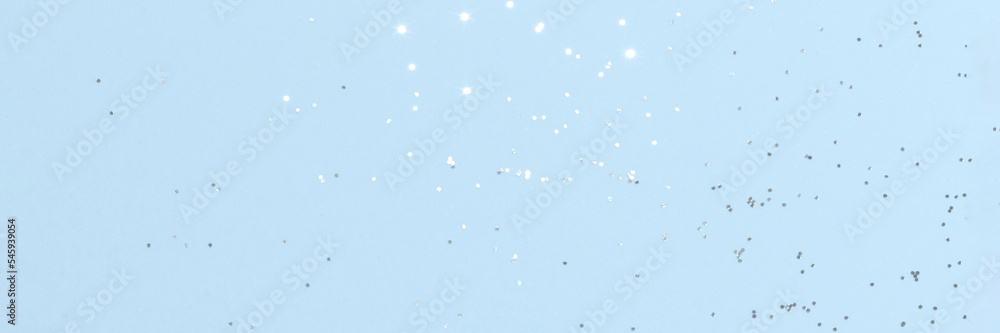 Sparkling silver glitter on blue background banner texture. Abstract holiday blurred lights header. Wide screen wallpaper. Panoramic web banner with copy space for design Sparkling silver glitter on blue background banner texture. Abstract holiday blurred lights header. Wide screen wallpaper. Panoramic web banner with copy space for design
