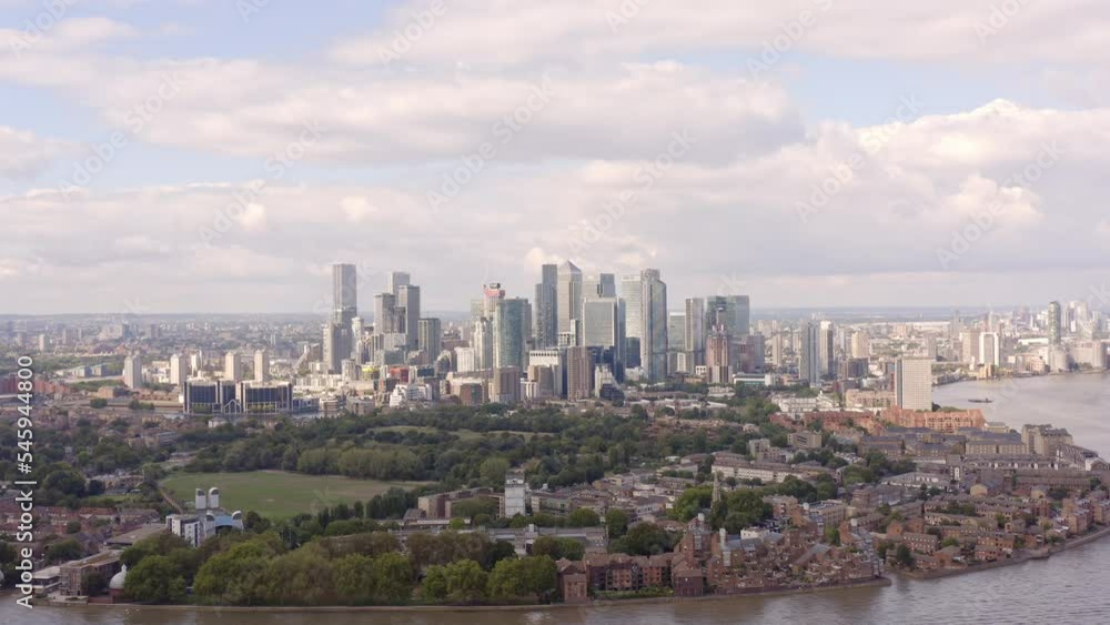 Canary Wharf entirety skyline from the east, the tall residential and business buildings, and the low-rise docklands’ Isle of Dogs nearby, drone shot.