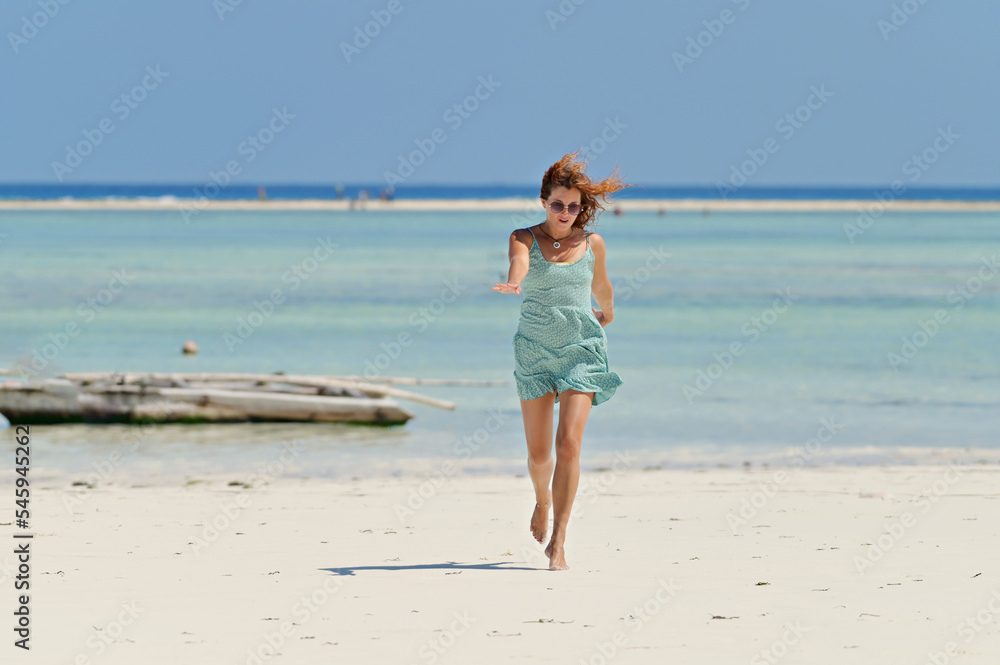Young pretty woman on the tropical sandy beach with turquoise water sea background, Zanzibar Young pretty woman on the tropical sandy beach with turquoise water sea background, Zanzibar
