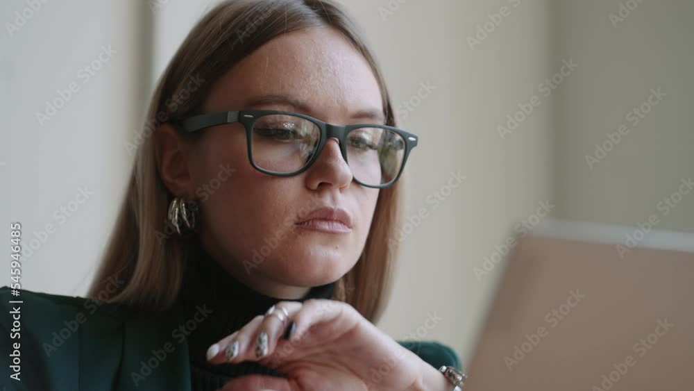 portrait of attractive adult woman with glasses working with laptop, looking at display, closeup portrait of attractive adult woman with glasses working with laptop, looking at display, closeup