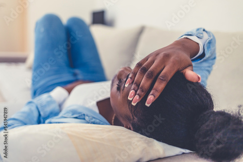 Cropped shot of an attractive young woman lying down on her bed and suffering from period pains at home. Healthcare and Medicine. photo