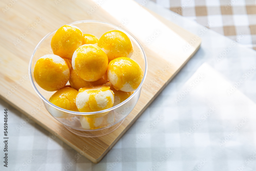 A cup of Sweet Filling with Salted Egg on a wooden cutting board ready for eat. A cup of Sweet Filling with Salted Egg on a wooden cutting board ready for eat.