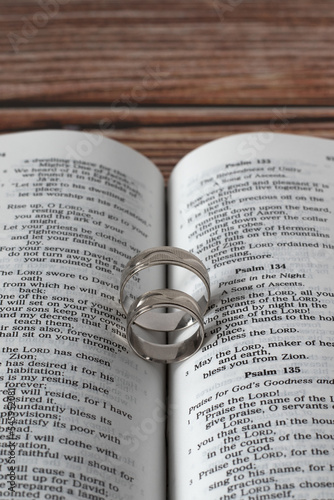 Εκτύπωση καμβά Two wedding rings on open Holy Bible Book placed on wooden background