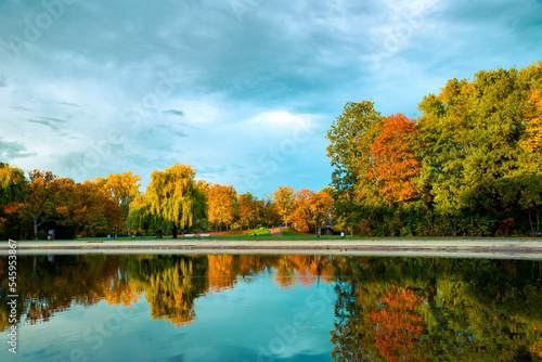 Beautiful autumn landscape, trees in the morning light are reflected in the lake