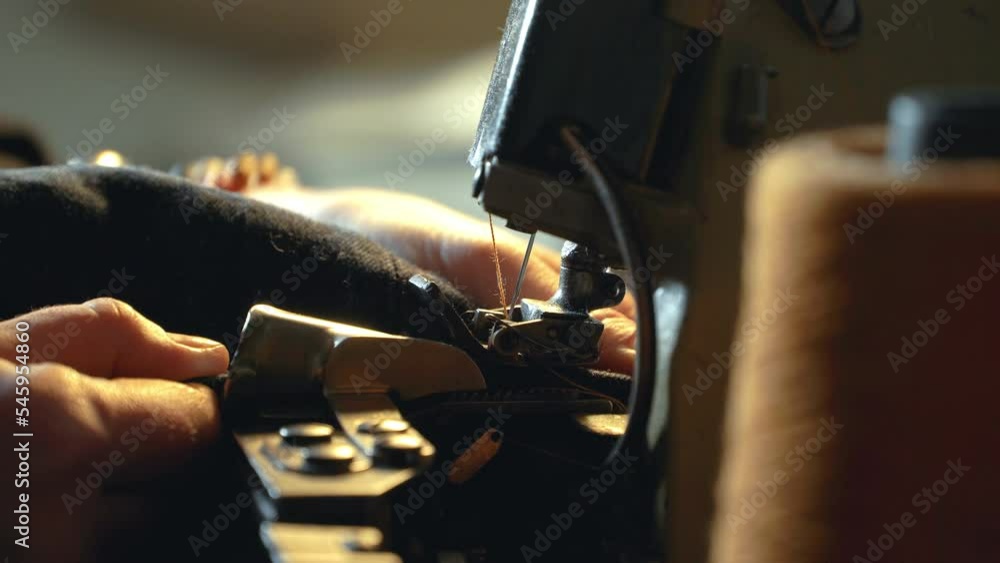 A female tailor seamstress hemming old jeans with vintage authentic machine in in a workshop repairing old denim clothes. Small family business, tailoring and repair of clothes, handmade, startup A female tailor seamstress hemming old jeans with vintage authentic machine in in a workshop repairing old denim clothes. Small family business, tailoring and repair of clothes, handmade, startup