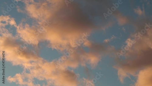 Dramatic sky with passing red, yellow, orange clouds during sunset during windy evening