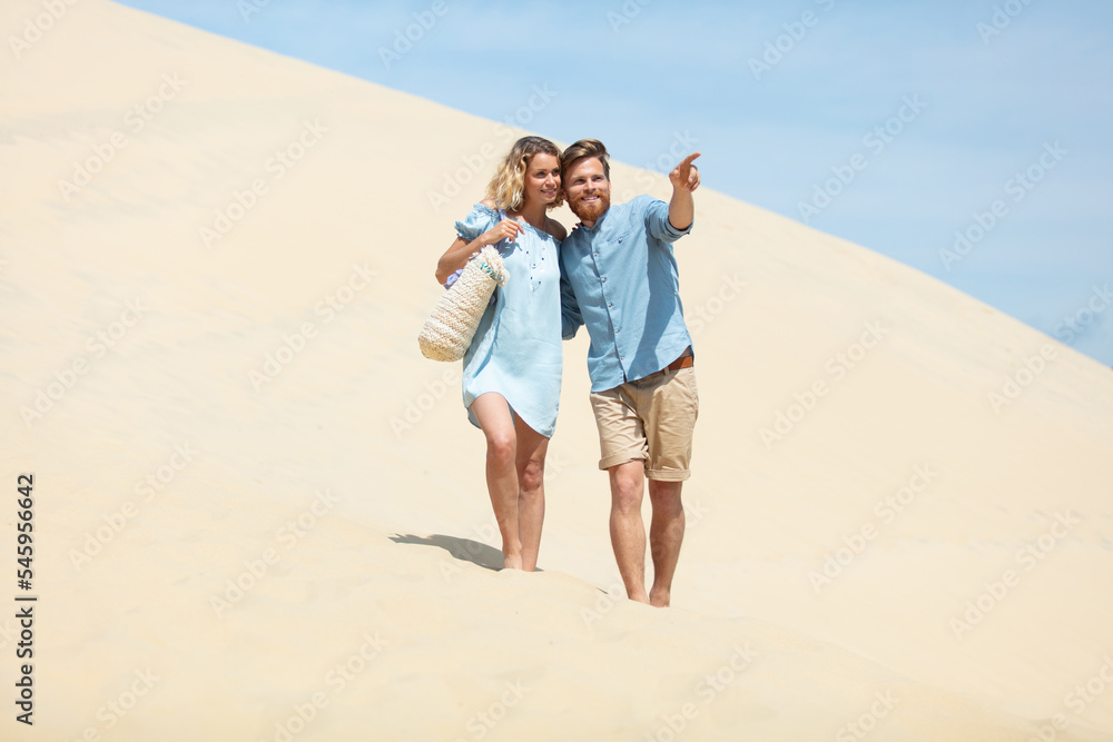 couple walking on a deserted sand dune