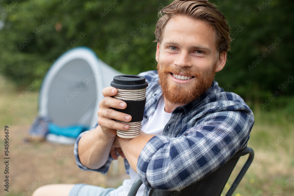 man is enjoying cup of coffee outside the tent man is enjoying cup of coffee outside the tent