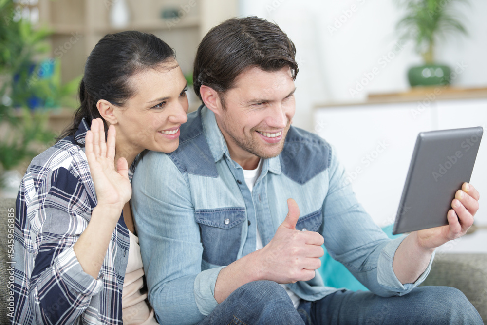 couple using a tablet computer in their living room couple using a tablet computer in their living room