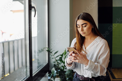 Beautiful woman working on her laptop and phone on a stylish urban restaurant