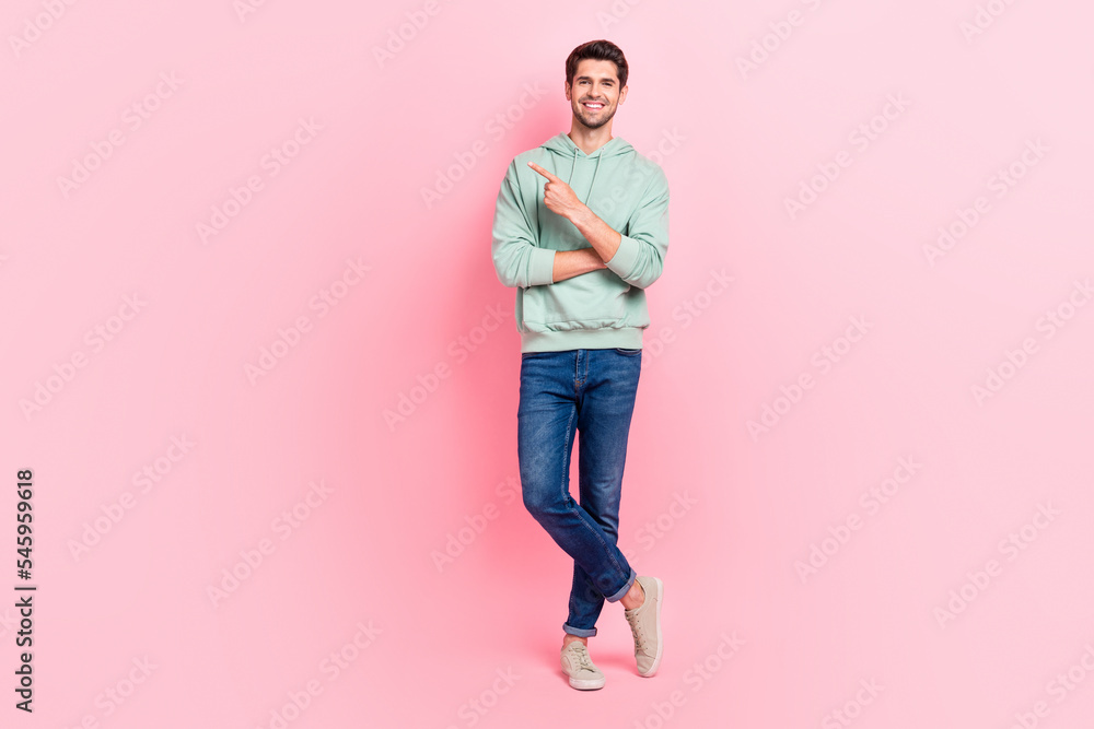 Full length photo of nice cool boy dressed khaki clothes denim arm direct empty space banner announcement isolated on pink color background Full length photo of nice cool boy dressed khaki clothes denim arm direct empty space banner announcement isolated on pink color background