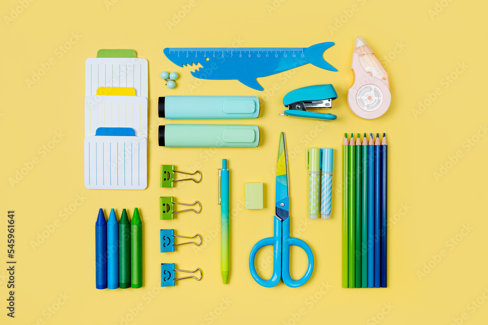 School stationery is arranged neatly on yellow background. Concept back to school. Workplace organization School stationery is arranged neatly on yellow background. Concept back to school. Workplace organization