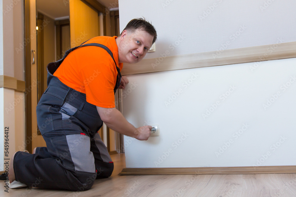 worker changes a faulty socket in a house. worker changes a faulty socket in a house.