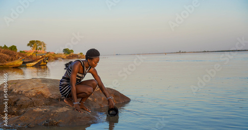 Fototapet Beautiful African woman fetching water from the River