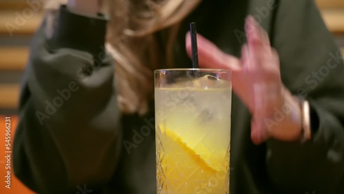 Young woman drinking lemonade with a cocktails tube in the restaurant