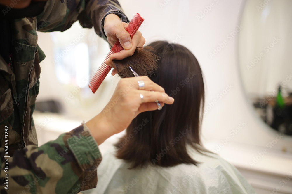 Fototapeta premium 女性の髪を切る男性美容師