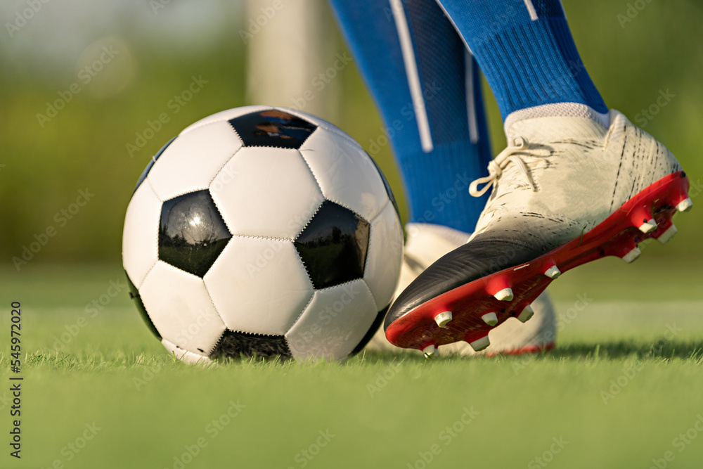 Athlete standing with ball on football field during sunrise, soccer ball in net on sky background, ball movement, popular sports on football club, World cup. Athlete standing with ball on football field during sunrise, soccer ball in net on sky background, ball movement, popular sports on football club, World cup.