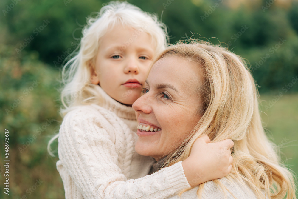 Little blond girl hugging her mom