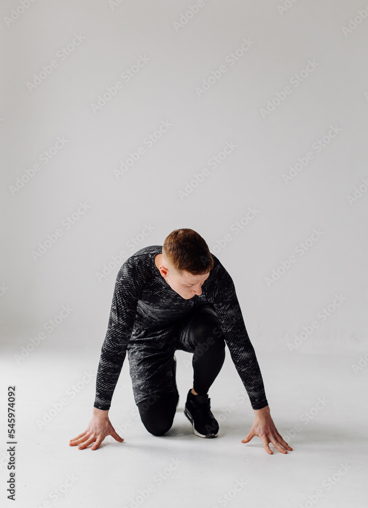 Fototapeta premium Athletic young man doing workouts at home, man doing training, warm up before weight exercise.