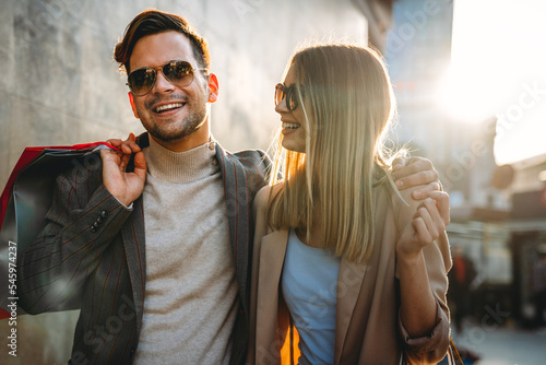 Couple of tourists walking in a city street and shopping together. People shopping fun concept