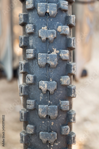 A studded mountain bike tire with sand. Close-up