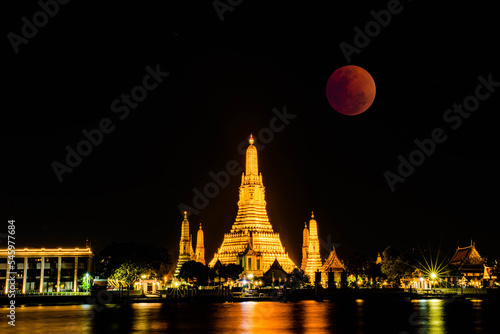 BANGKOK, THAILAND - November 8, 2022 : Lunar Eclipse,  Super Red Full Moon taken from top side of “Wat Arun Temple”,  This is a wonderful natural phenomenon with the view along Chao Praya River. © Bobbyphotos