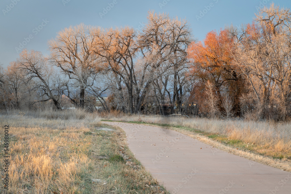 Obraz premium paved bike trail along the Poudre River in Fort Collins area in northern Colorado, mid November fall scenery, recreation and commuting concept