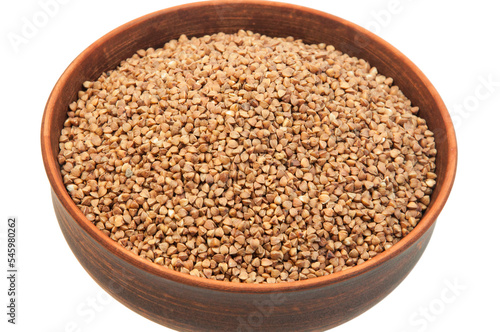 buckwheat in a clay bowl on a white background. the concept of a good harvest of buckwheat