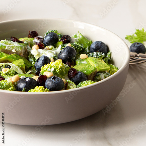 bowl with salad with broccoli and avocado on a light table